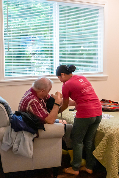 image of staff member taking a resident's blood pressure at the start of the day